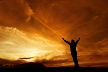 Giving thanks: Man standing with arms outstretched in thanks