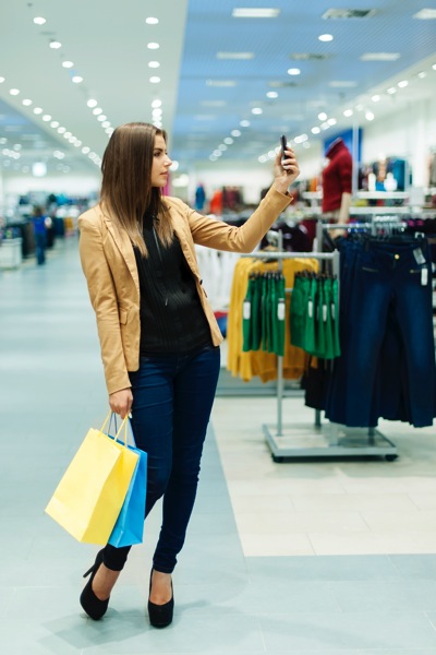 Will e-commerce kill retail? Woman shopping in store with her phone