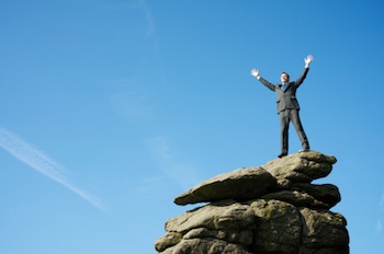 Opportunity (Leap Day Edition): Successful business man posing at top of hill.