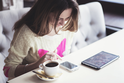 6 insights into customer experience and digital transformation: Young woman shopping on mobile phone in cafe
