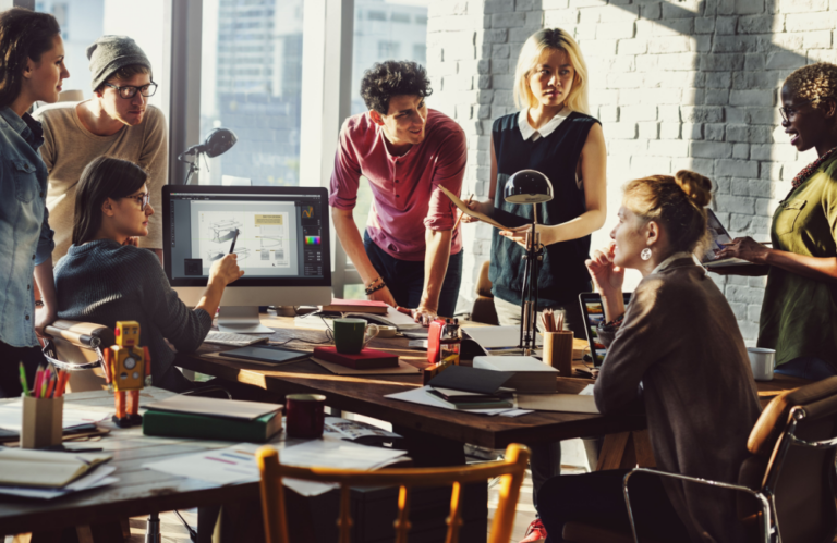 Diverse team collaborating around a table to illustrate the idea of social media for your business