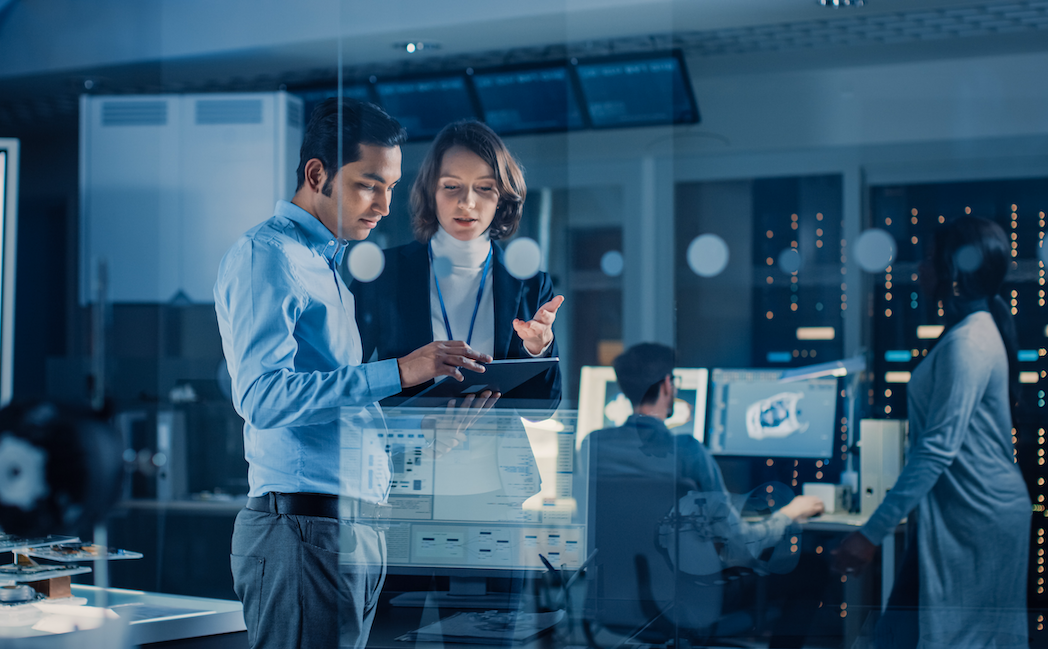 People communicating in high-tech workspace to illustrate the question, "What if I'm wrong about AI and marketing jobs?"