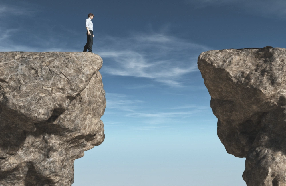 Picture of a young man looking at a big gap in the mountains to illustrate the idea of the AI value gap many businesses face in making AI work
