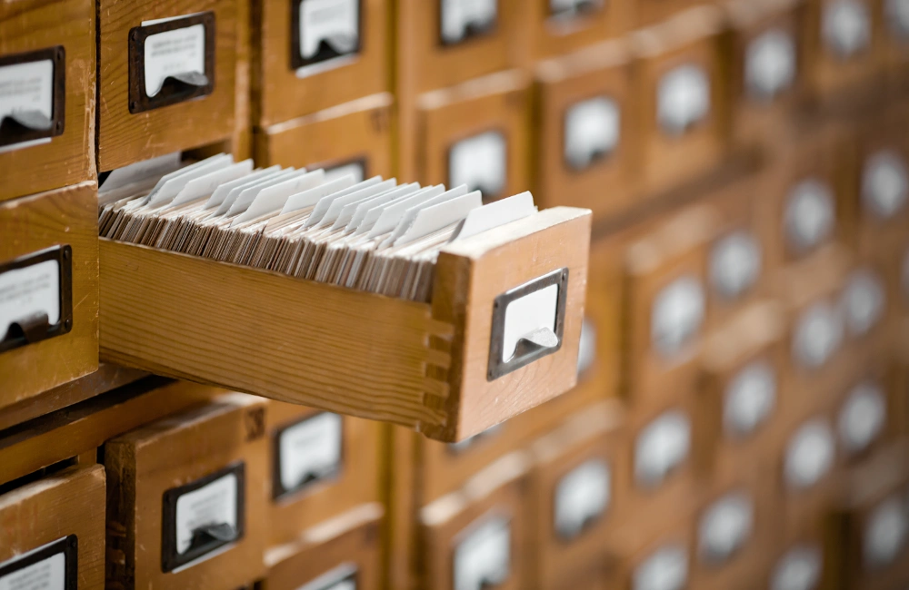 Photo of wooden card catalog drawer open to illustrate the foundational idea of moving from card catalogs to concierges — and making SEO and GEO work together