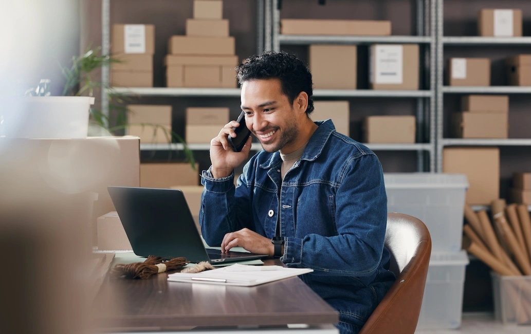 Man on phone working on laptop to illustrate the idea of who owns your customer