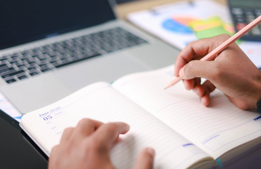 Photo of man writing in notebook to illustrate the idea that the brands AI recommends give customers something generic content never could