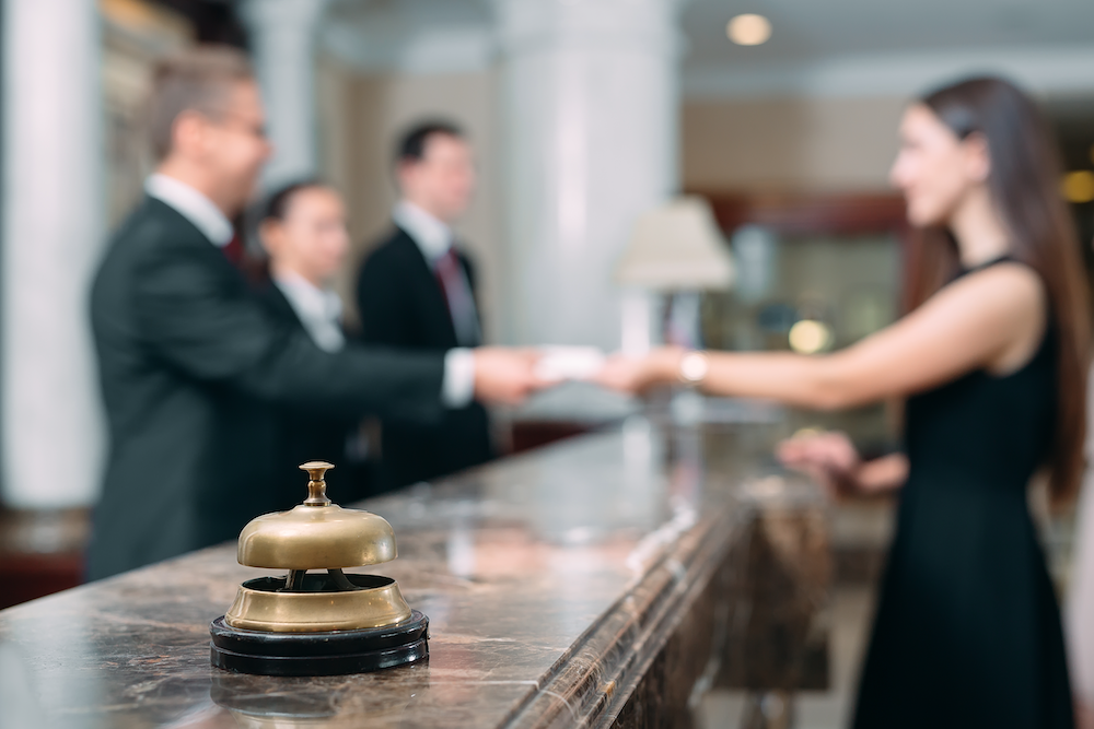 Woman checking into a hotel to illustrate the idea that Google built an AI hotel booking engine and independent hotels weren't invited.