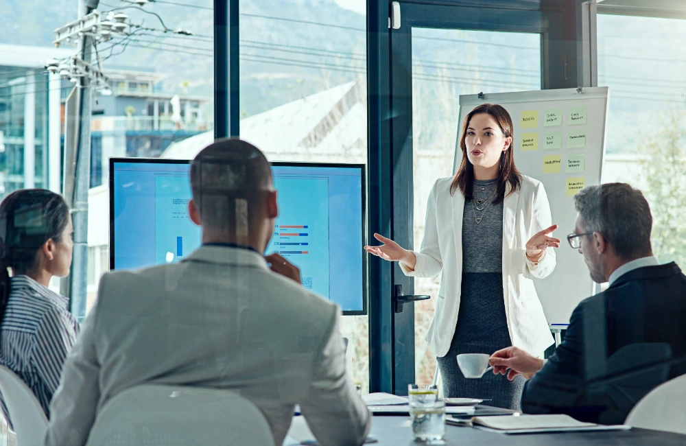 Photo of woman presenting budget ideas to executives to illustrate the idea of winning your digital budget next year.